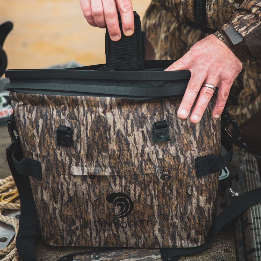 Dry Pocket's Mossy Oak Bottomland camo waterproof, scent proof, floating, and magnetic double lock, auto-sealing 10 can tote cooler or dry bag. 