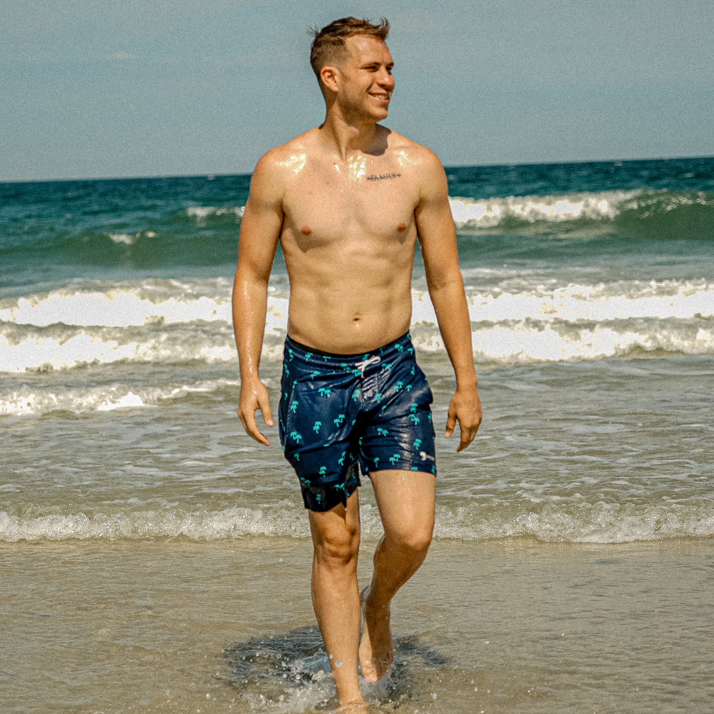 Dry Pocket waterproof swim trunks with palm trees. 