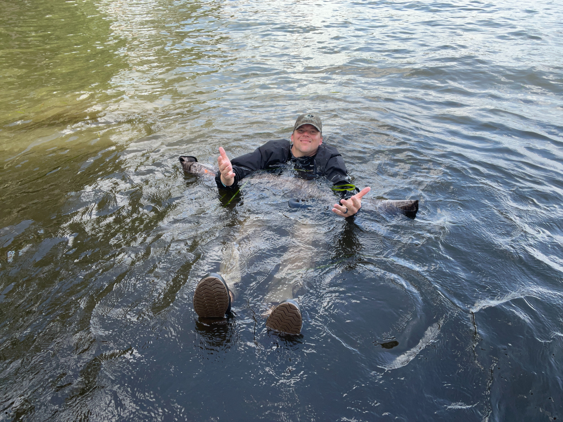 Man floating on a Dry Pocket waterproof shotgun bag 