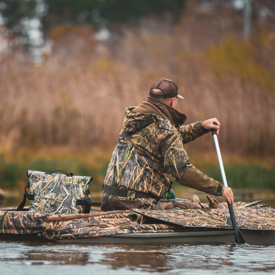 Dry Pocket's Mossy Oak Camouflage-patterned universal waterproof, scent proof, and floating magnetic double lock auto-sealing 10 can tote cooler and dry bag with a shoulder strap on a white background