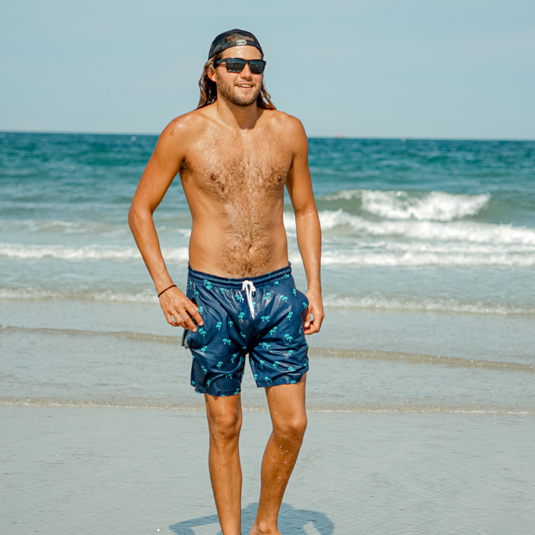 Dry Pocket waterproof swim trunks with palm trees. 