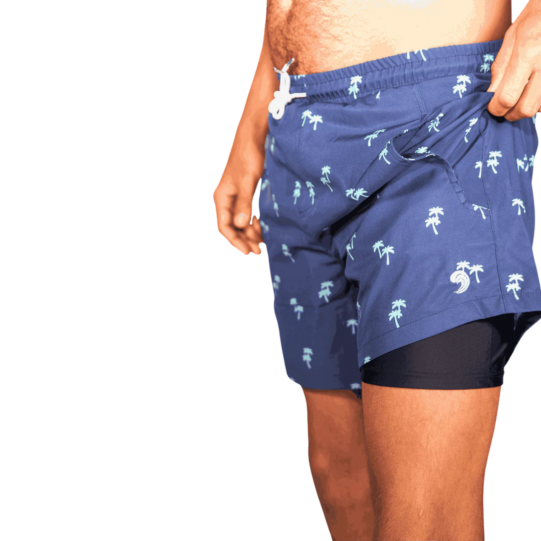 Dry Pocket waterproof swim trunks with palm trees. 