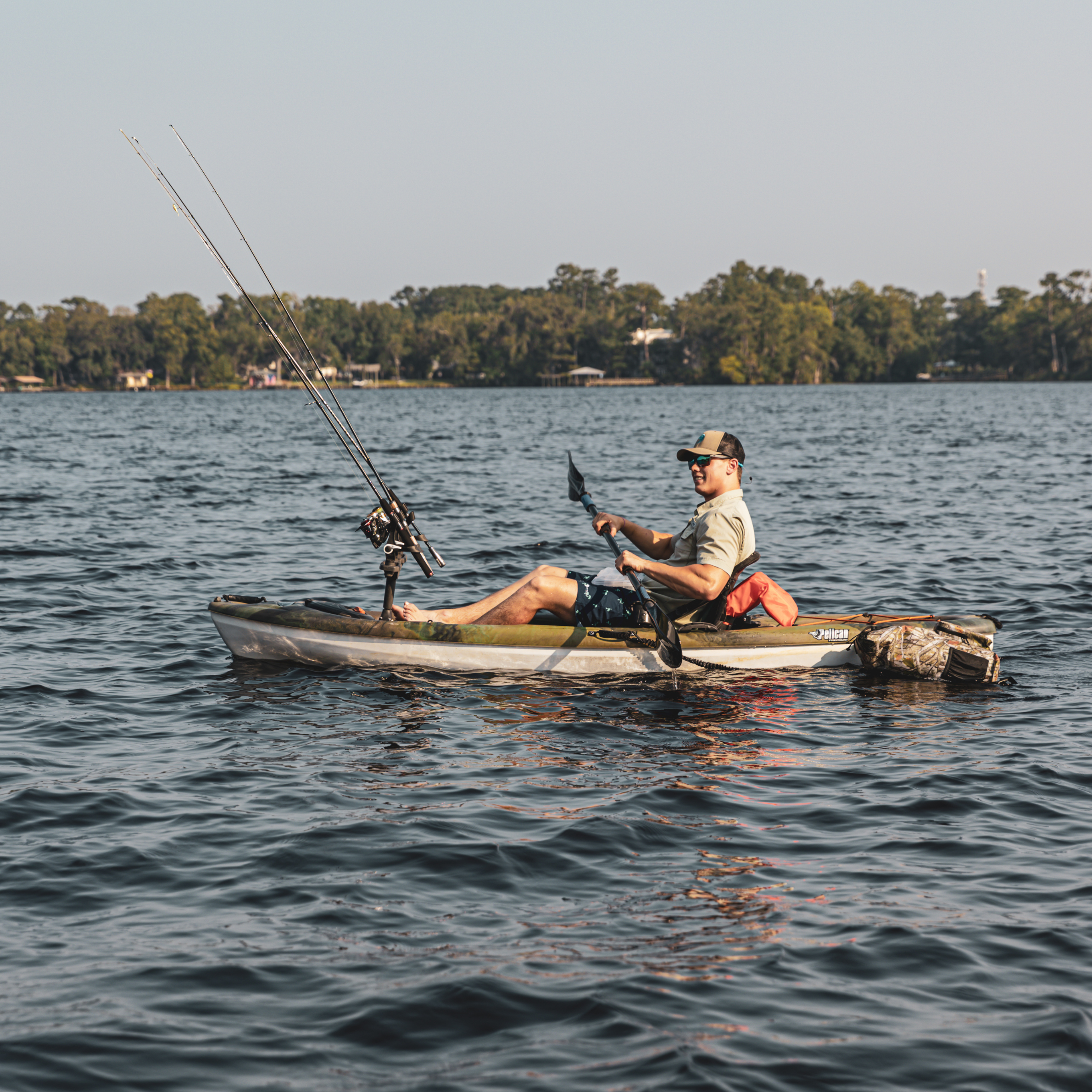 Man fishing out of a kayak with a Dry Pocket waterproof backpack dry bag floating behind him. 