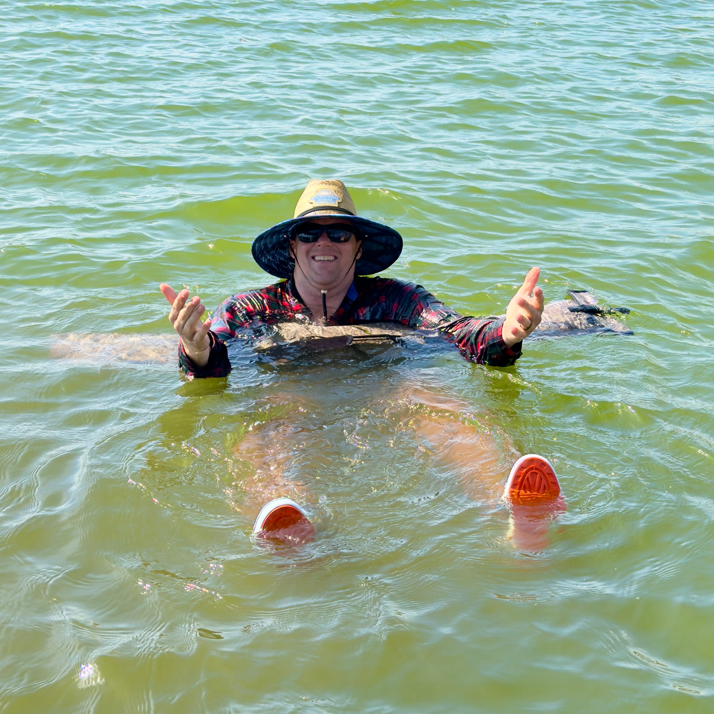 Man floating on a Dry Pocket waterproof shotgun bag 